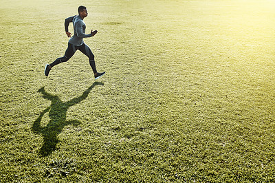 Buy stock photo Full length shot of a handsome and athletic young man running across an open field