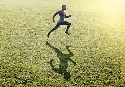 Buy stock photo Full length shot of a handsome and athletic young man running across an open field