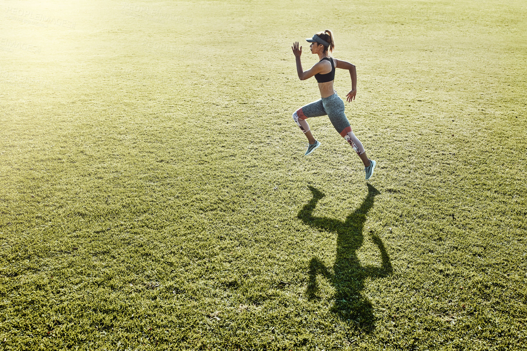 Buy stock photo Full length shot of an attractive and athletic young woman running across an open field