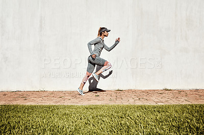 Buy stock photo Full length shot of an attractive and athletic young woman running on a path through the park