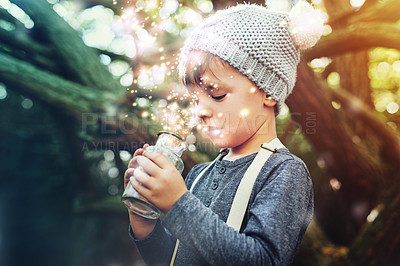 Buy stock photo Shot of a little boy catching fireflies in a jar outside