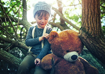 Buy stock photo Shot of a little boy playing with a teddybear outside
