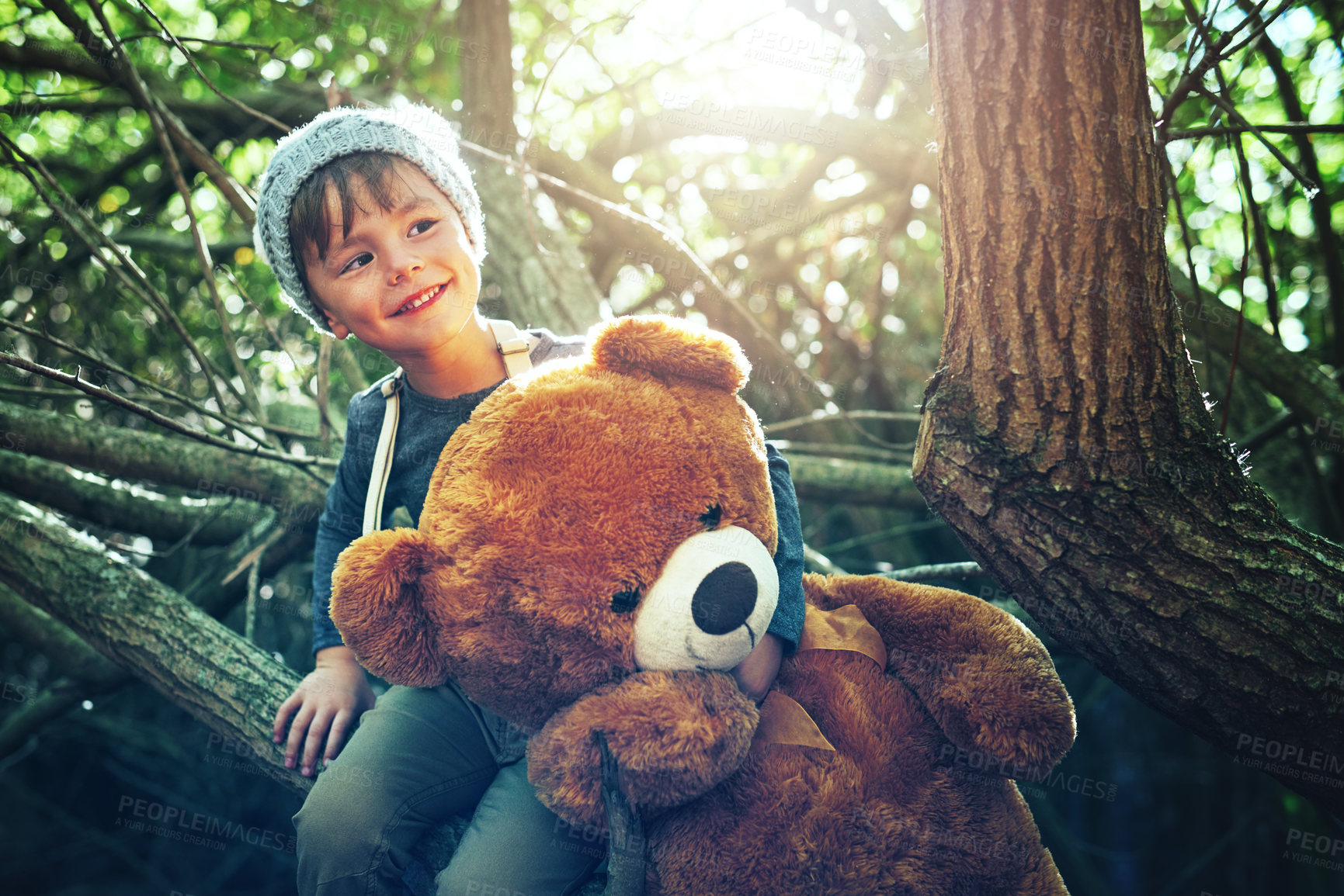 Buy stock photo Shot of a little boy playing with a teddybear outside