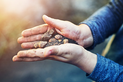 Buy stock photo Closeup shot of a little boy holding soil and stones in his hands