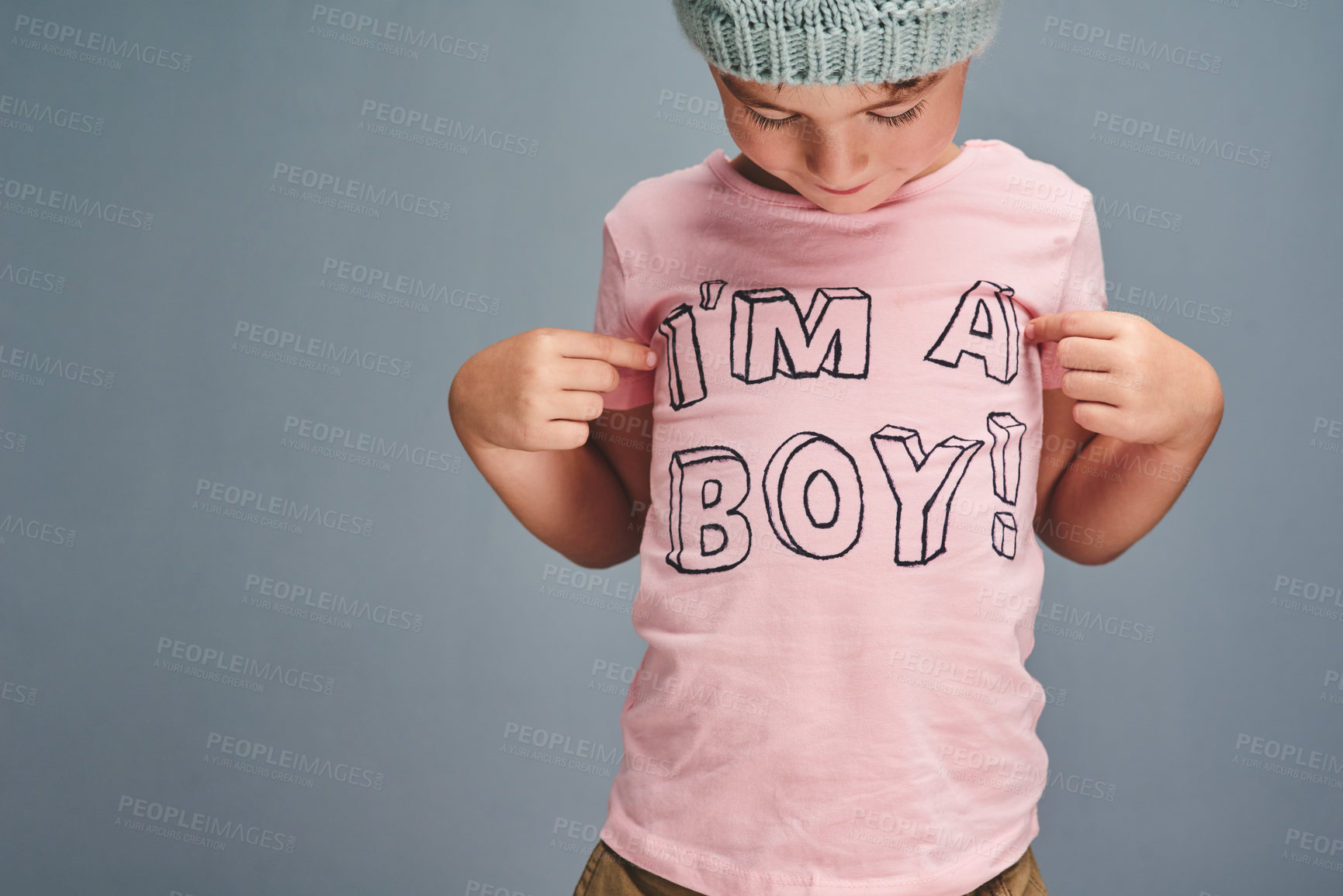 Buy stock photo Studio shot of a boy wearing a t shirt with “I’m a boy” printed on it against a grey background
