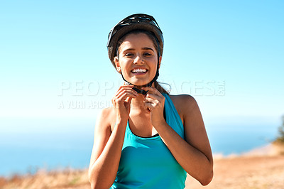 Buy stock photo Cropped portrait of a young woman putting on her helmet before her ride
