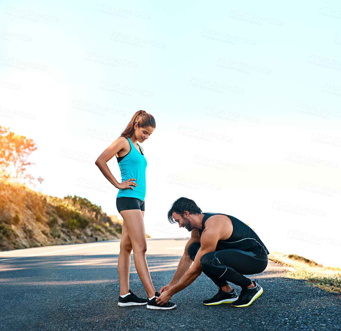 Buy stock photo Outdoor, couple and tie lace on road ready for fitness, exercise and training for wellness or health. People, woman and man help with shoes on concrete, nature and before running for sports challenge