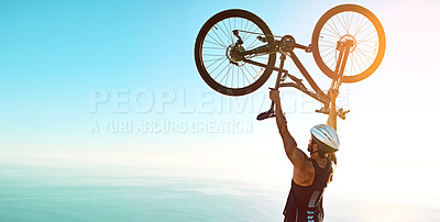 Buy stock photo Rearview shot of a male cyclist lifting his mountain bike into the air