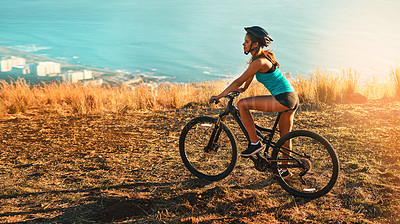 Buy stock photo Full length shot of a female cyclist out for a ride on her mountain bike