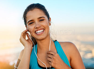 Buy stock photo Cropped portrait of a young woman listening to music while out for a run