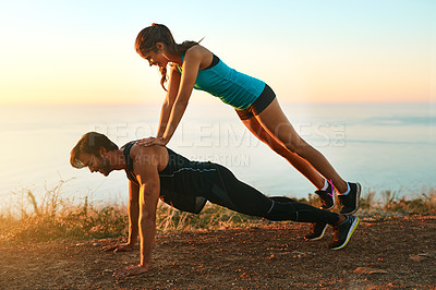Buy stock photo Full length shot of an attractive young woman on top of her boyfriend's back while he does push-ups