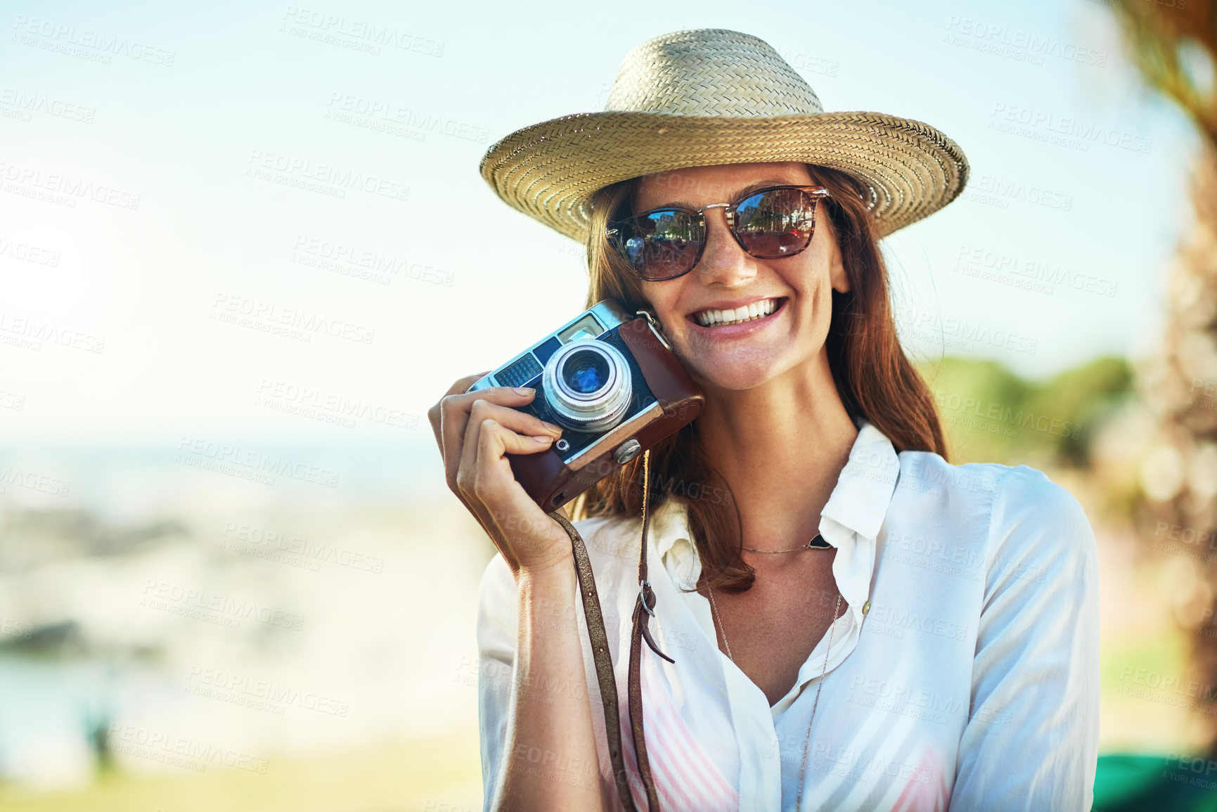 Buy stock photo Cropped portrait of an attractive young woman using a camera on a summer’s day outdoors