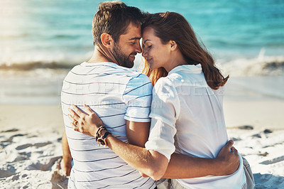 Buy stock photo Rearview shot of a young couple kissing on a summer’s day at the beach