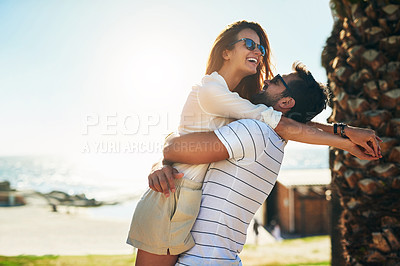 Buy stock photo Shot of a happy young couple embracing while enjoying a summer’s day outdoors