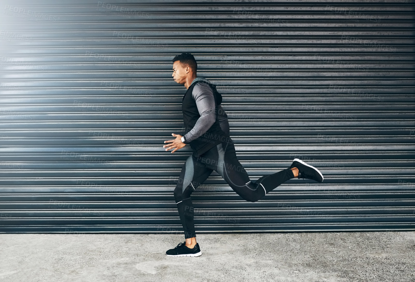 Buy stock photo Shot of a sporty young man running against a grey background