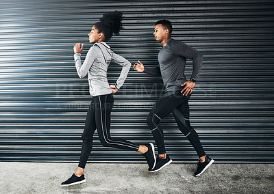 Buy stock photo Shot of a sporty young couple running against a grey background