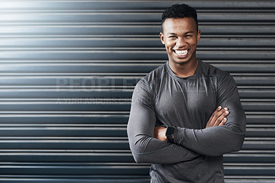 Buy stock photo Portrait of a sporty young man standing with his arms crossed against a grey background