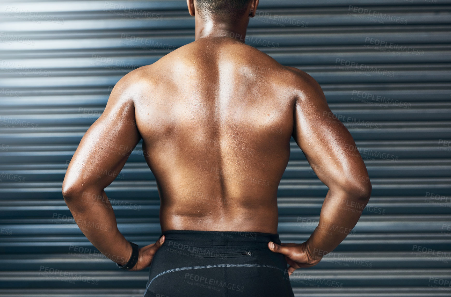 Buy stock photo Rearview shot of a muscular young man standing against a grey background