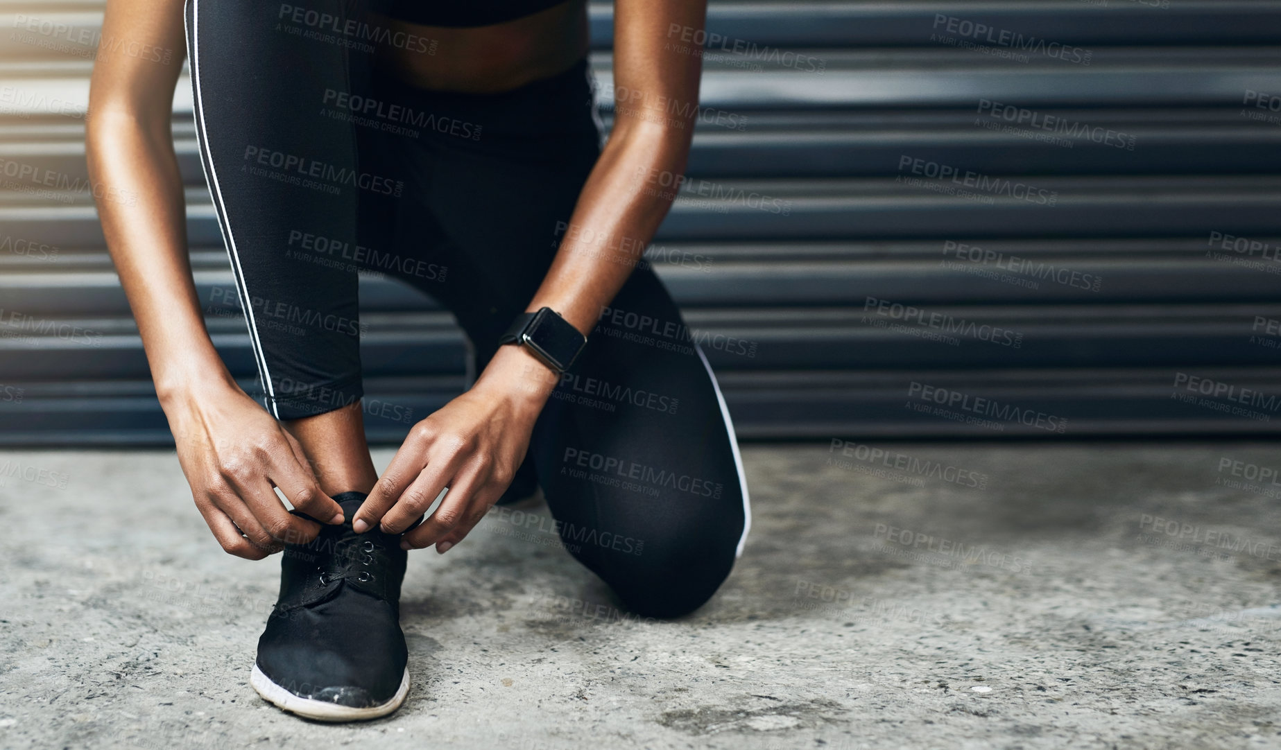 Buy stock photo Closeup shot of a sporty woman tying her shoelaces while exercising against a grey background