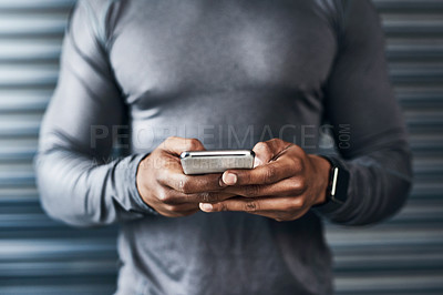 Buy stock photo Closeup shot of a sporty man using a cellphone against a grey background