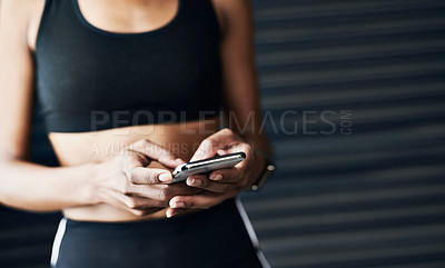 Buy stock photo Closeup shot of a sporty woman using a cellphone against a grey background