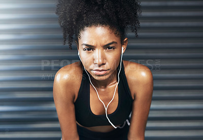 Buy stock photo Portrait of a sporty young woman taking a break while exercising against a grey background