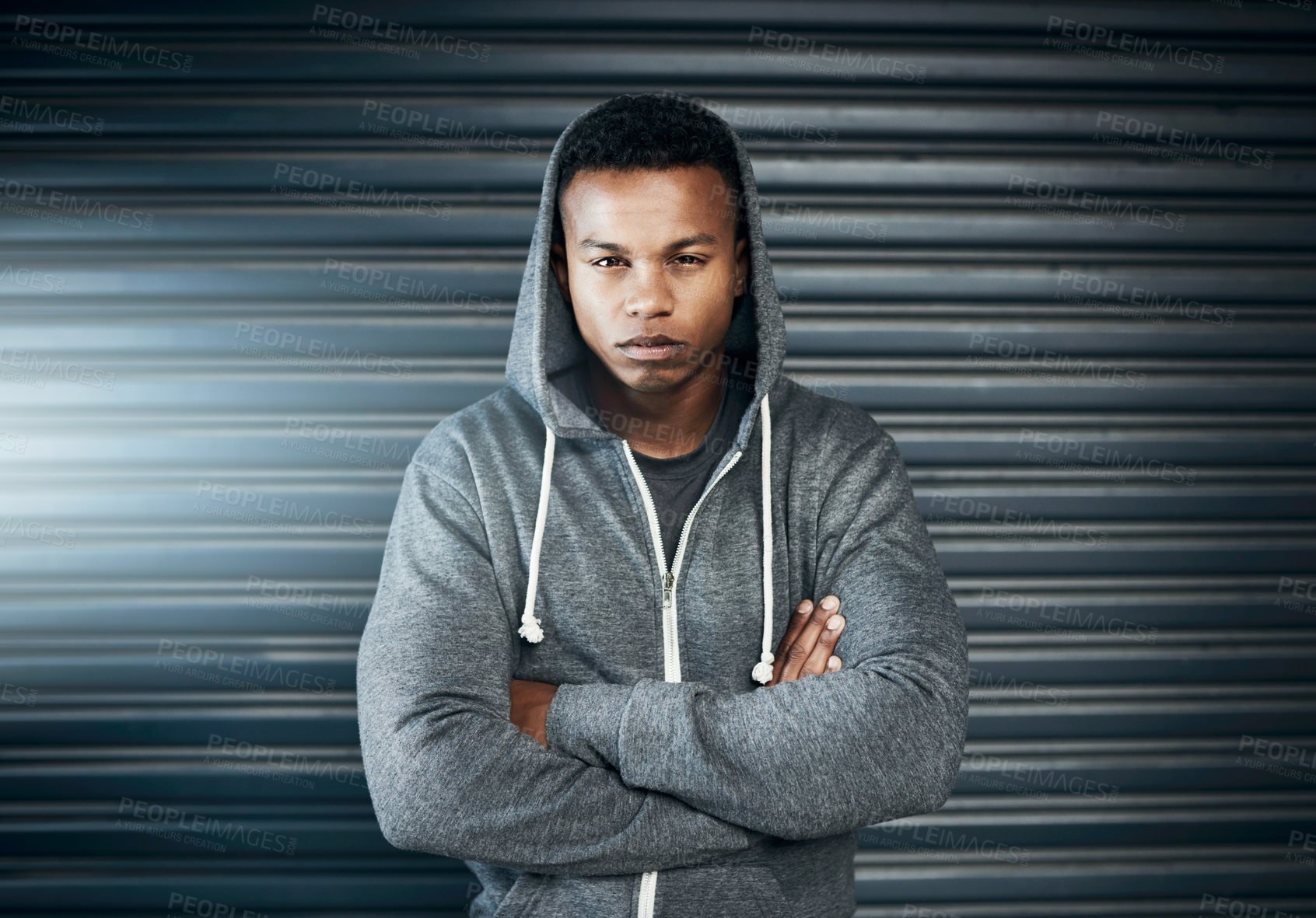 Buy stock photo Portrait of a sporty young man standing with his arms crossed against a grey background