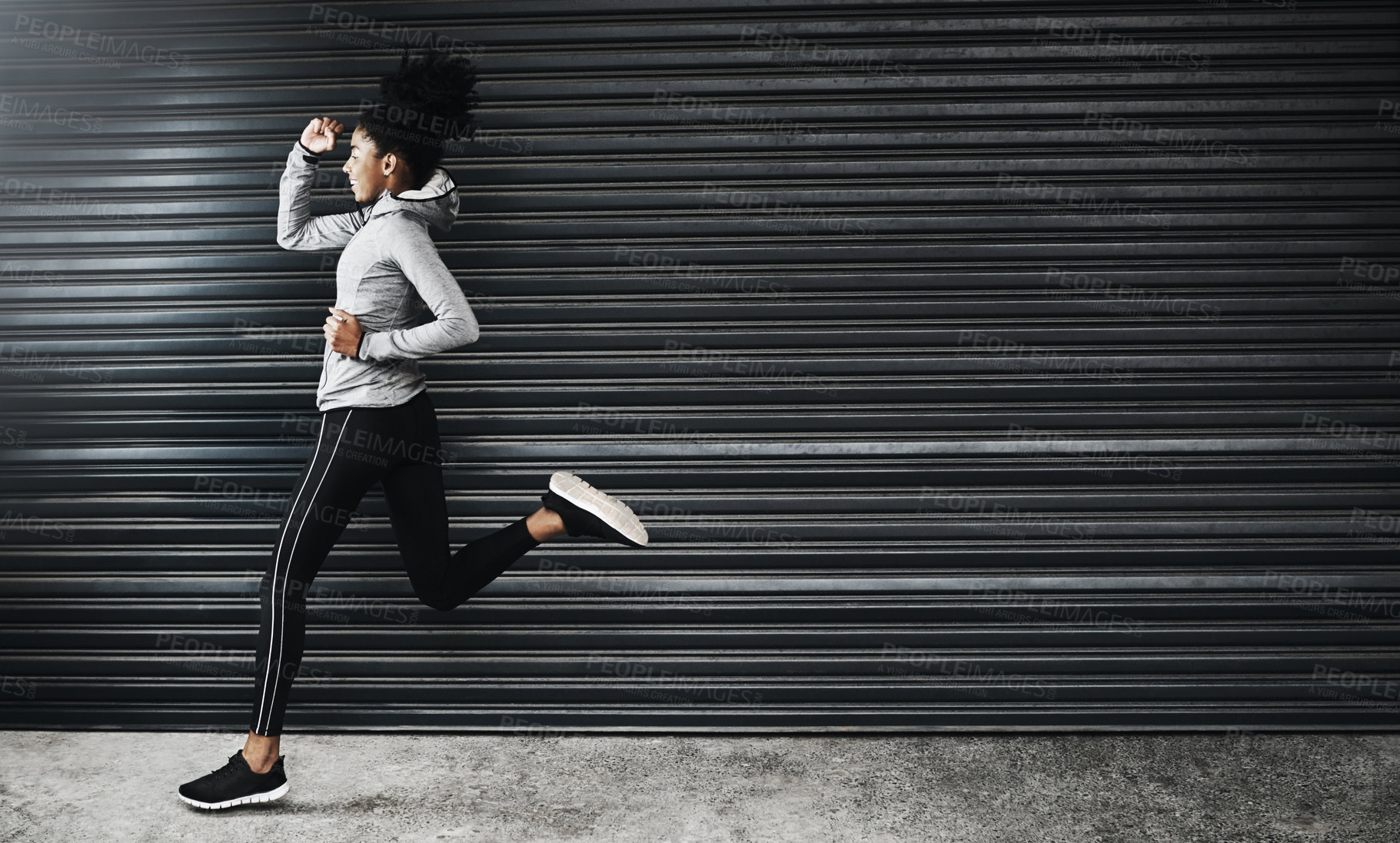 Buy stock photo Shot of a sporty young woman running against a grey background