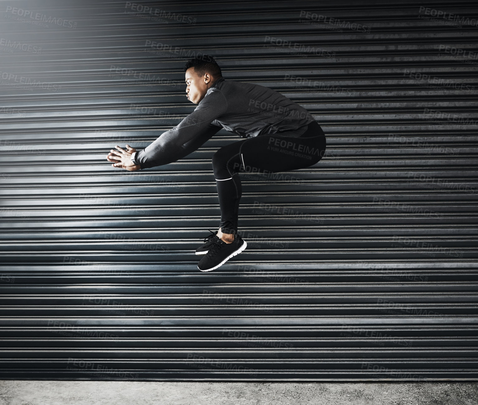 Buy stock photo Shot of a sporty young man jumping against a grey background