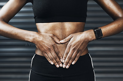 Buy stock photo Closeup shot of an sporty woman making a heart shape with her hands on her stomach against a grey background