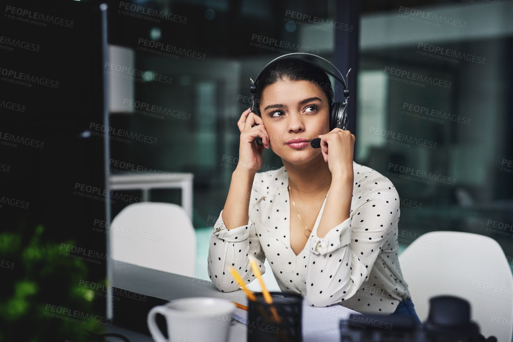 Buy stock photo Cropped shot of an attractive young businesswoman looking bored while working late in a call center