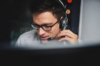 Buy stock photo Cropped shot of a handsome young businessman working late in a call center