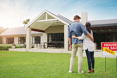 Buy stock photo Shot of a young couple admiring their newly purchased house