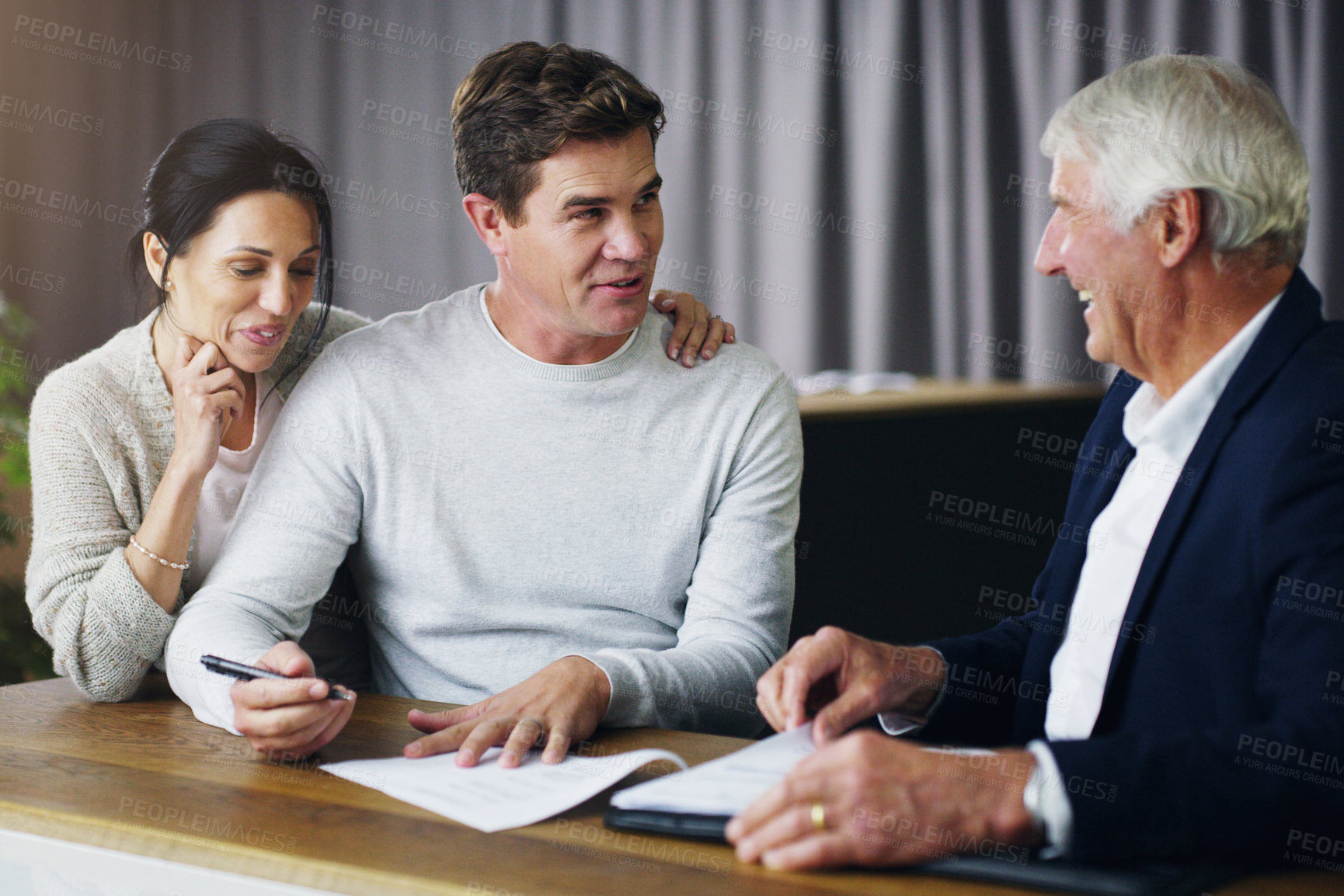 Buy stock photo Shot of a young couple meeting meeting with a mature consultant