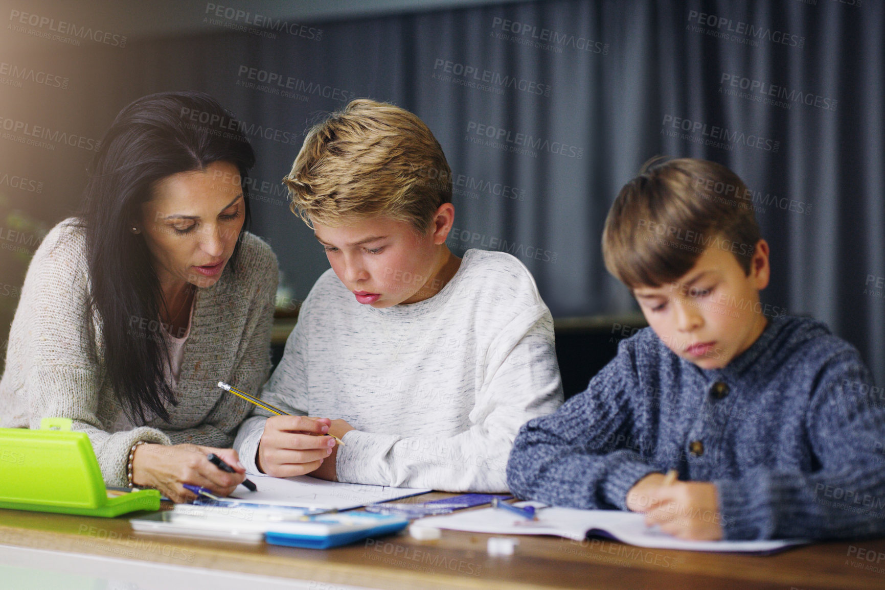 Buy stock photo Shot of a mother helping her sons with their homework