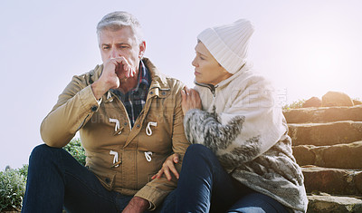 Buy stock photo Shot of an elderly couple looking very worried while sitting down outdoors