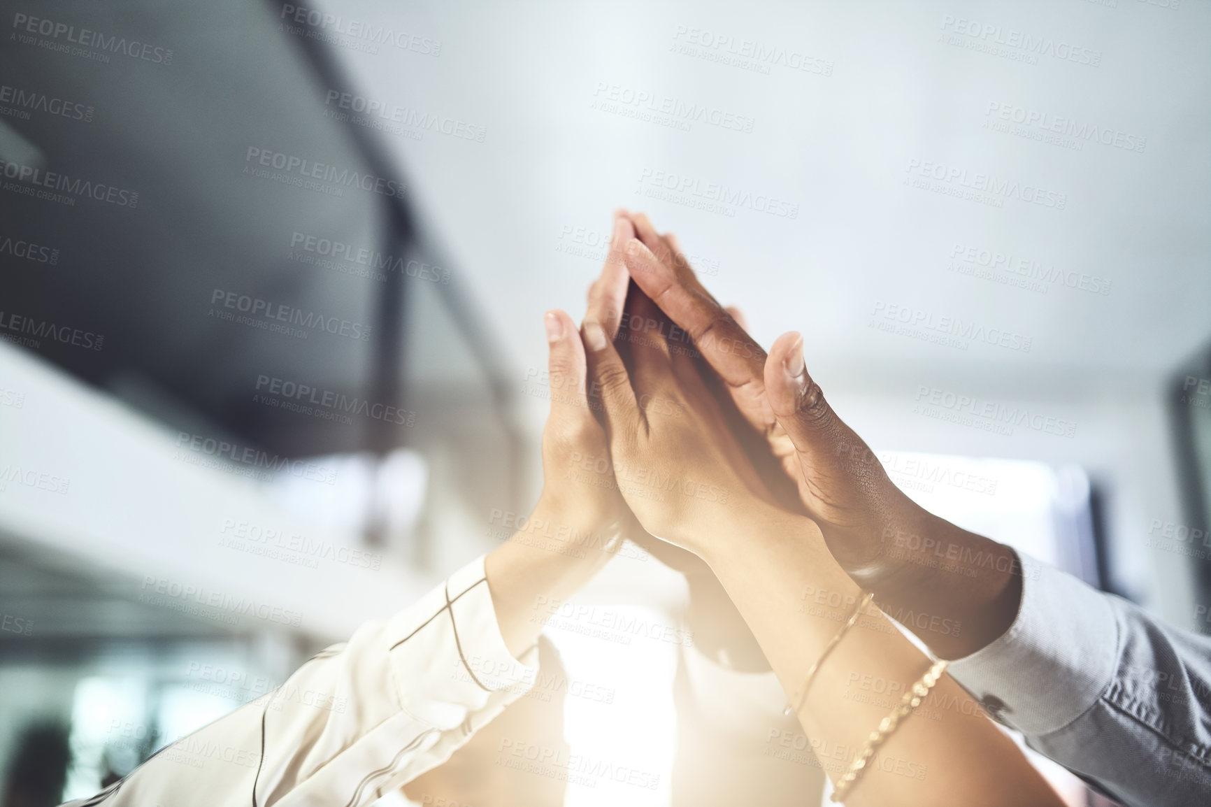 Buy stock photo Closeup shot of a group of businesspeople giving each other a high five in an office
