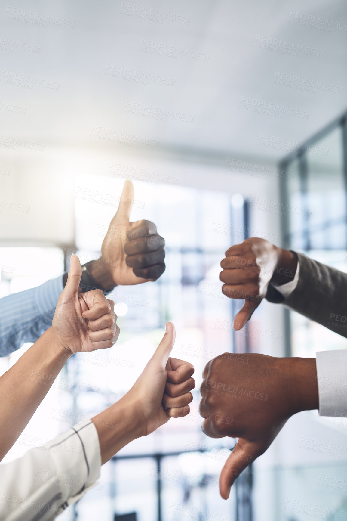 Buy stock photo Closeup shot of a group of businesspeople showing thumbs up and down in an office