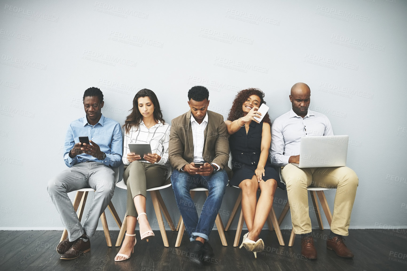 Buy stock photo Studio shot of a group of businesspeople using their wireless devices while waiting in line