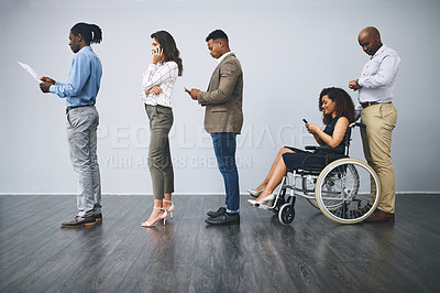 Buy stock photo Studio shot of a group of businesspeople waiting in a queue against a gray background