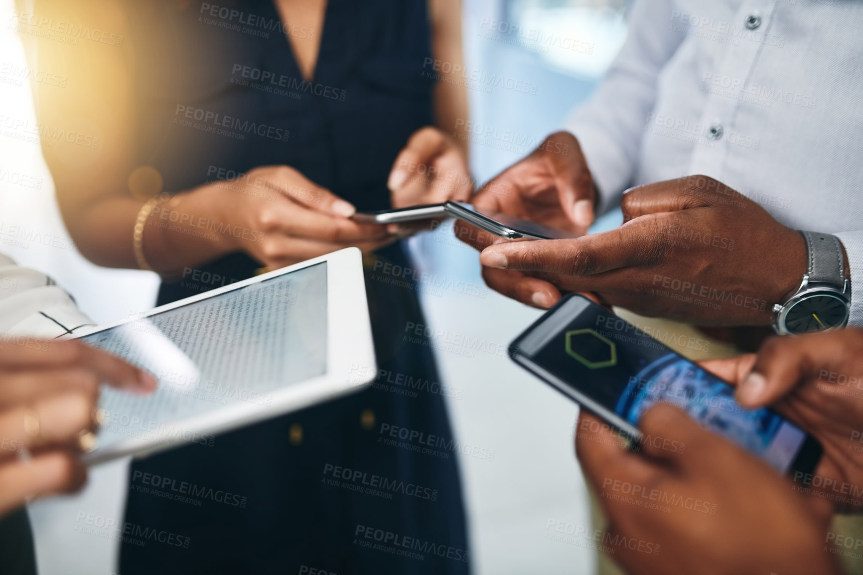 Buy stock photo Closeup shot of a group of businesspeople using digital devices in synchronicity in an office