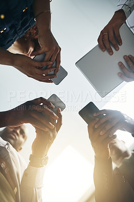 Buy stock photo Closeup shot of a group of businesspeople using digital devices in synchronicity in an office