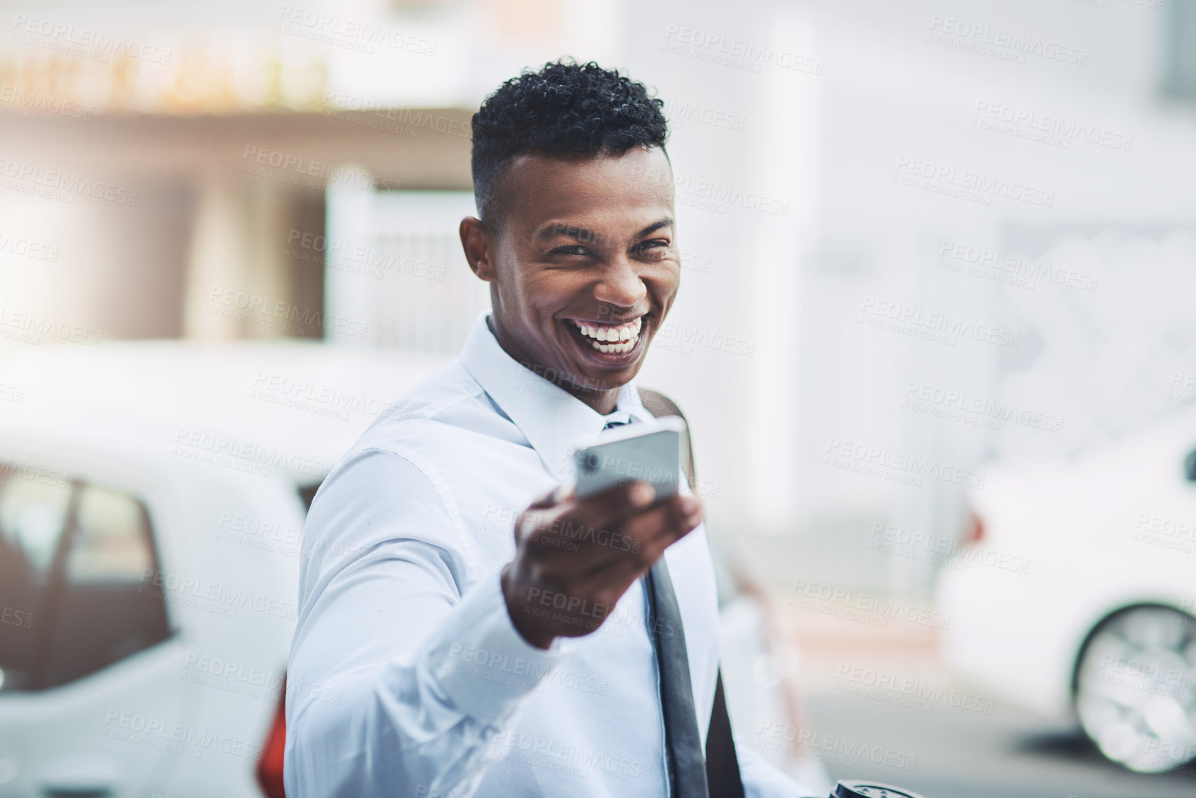 Buy stock photo Portrait of a handsome young businessman using a cellphone in the city
