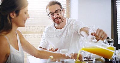 Buy stock photo Couple, home and relax at breakfast with orange juice, together for nutrition and bonding. Morning routine, healthy relationship and pouring drink with people in kitchen, vitamin c and wellness