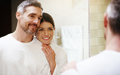 Buy stock photo Home, love and couple in a bathroom, mirror and cleaning with hygiene, hug and loving together. Partners, man and woman with a smile, reflection and fresh with skincare, grooming and morning routine