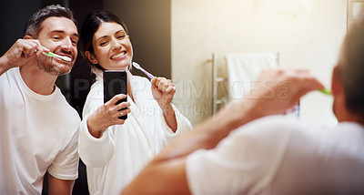 Buy stock photo Selfie, brushing teeth and couple in a bathroom, mirror and happiness with hygiene, home and wellness. Partners, man or woman with a smile, social media or mouth cleaning with reflection or self care