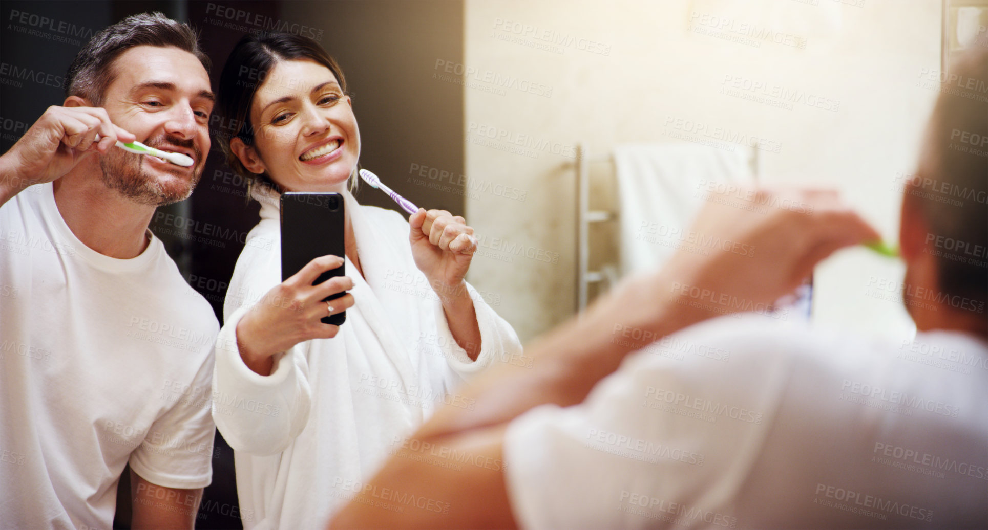 Buy stock photo Selfie, brushing teeth and couple in a bathroom, mirror and happiness with hygiene, home and wellness. Partners, man or woman with a smile, social media or mouth cleaning with reflection or self care
