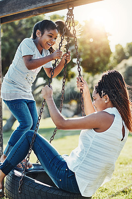 Buy stock photo Mother with daughter on swing at park, fun playing together with happiness and carefree outdoor. Love, care and bonding with family in nature, woman and girl enjoying time at playground with freedom