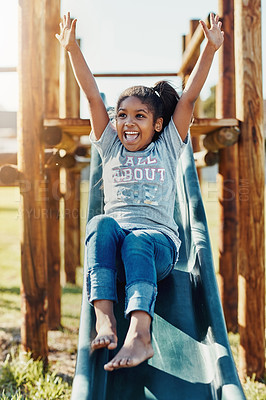 Buy stock photo Full length shot of an adorable little girl playing on a slide at the park