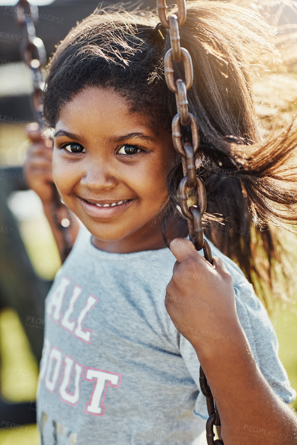 Buy stock photo Face, smile and girl on swing at playground for summer, growth and fun childhood activity with joy. Child, happy and portrait outdoor by park for playing games, relax and youth development with tire